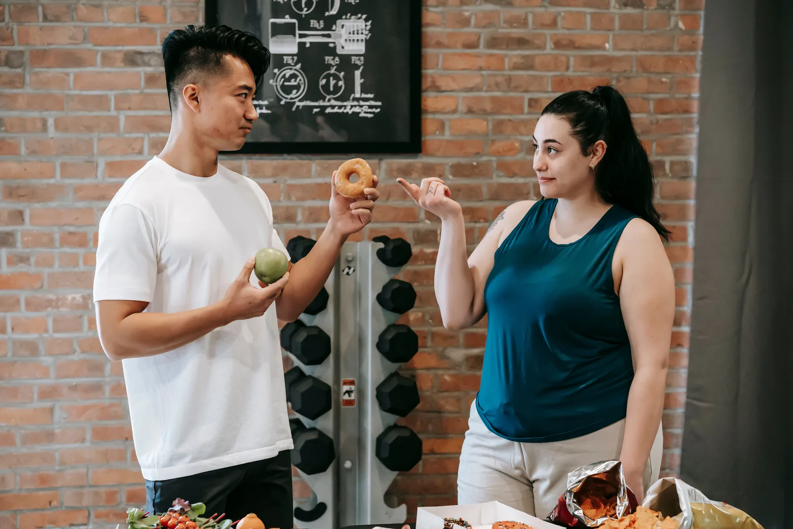 Two people discussing food choices in a gym