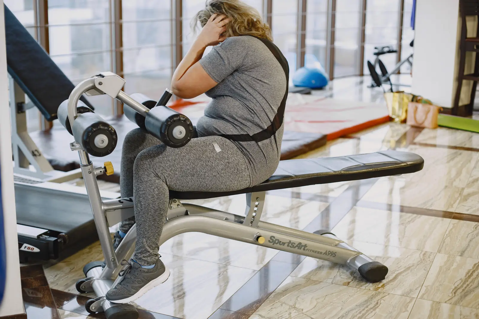 Sitting on a gym bench with head in hands