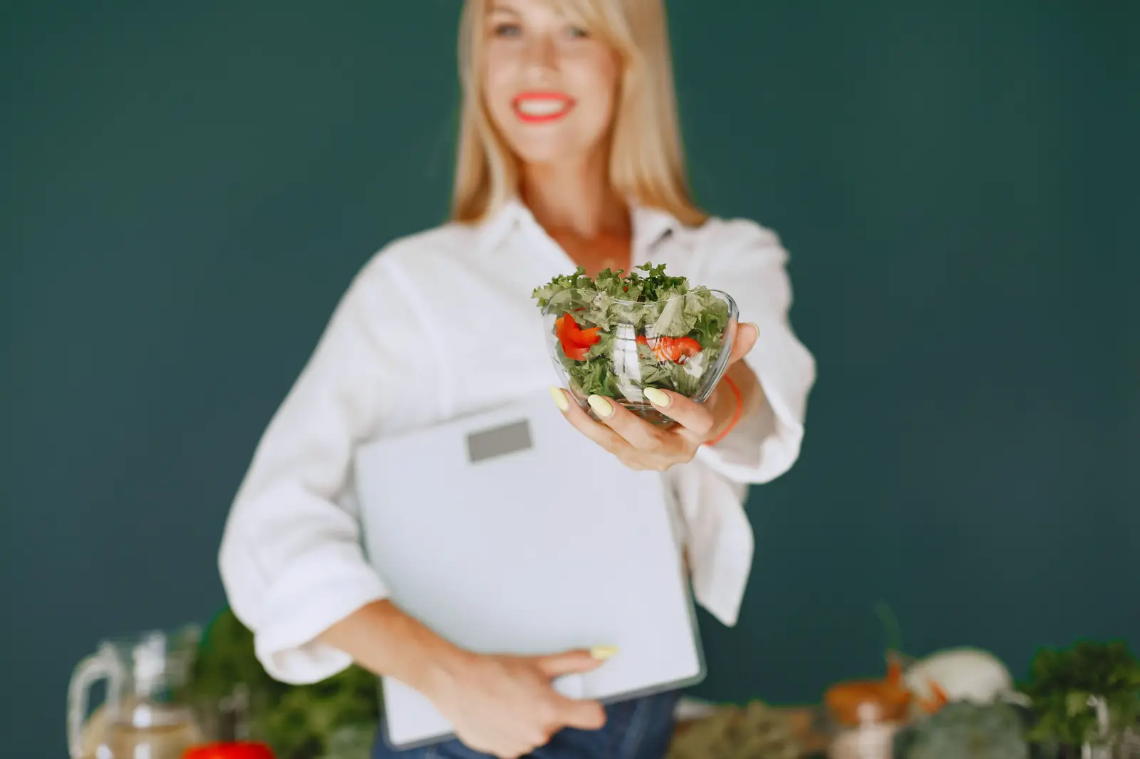 Holding a bowl of salad and a bathroom scale