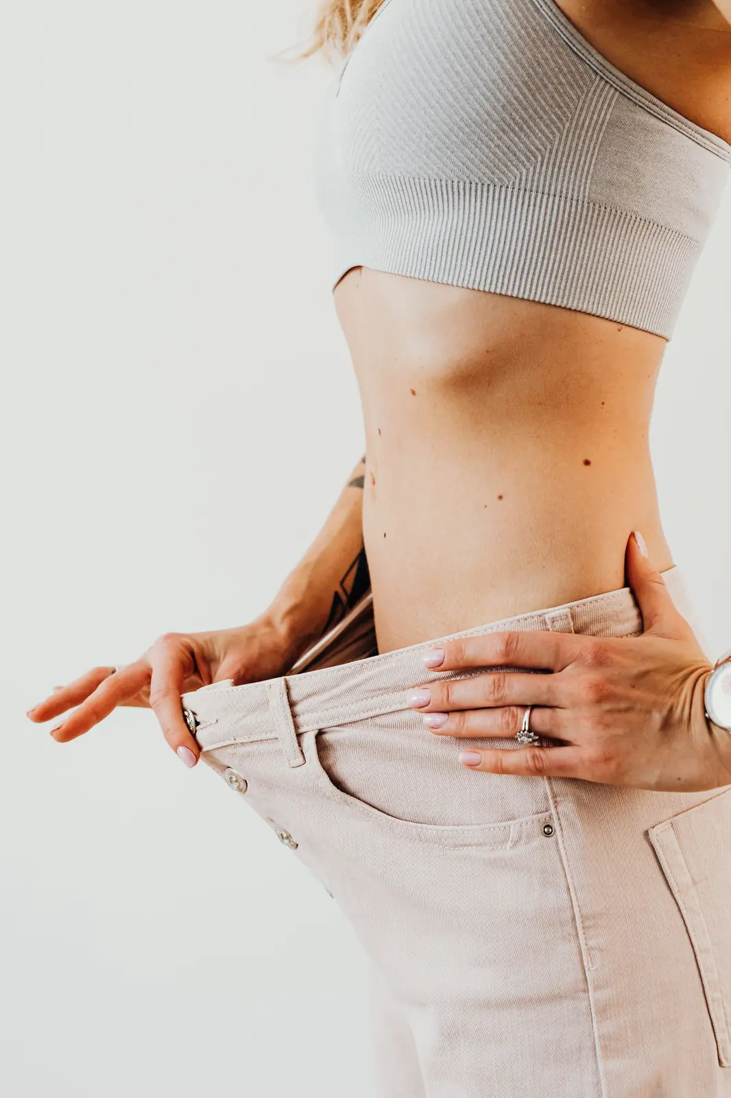 Loose jeans held out at the hip after weight loss