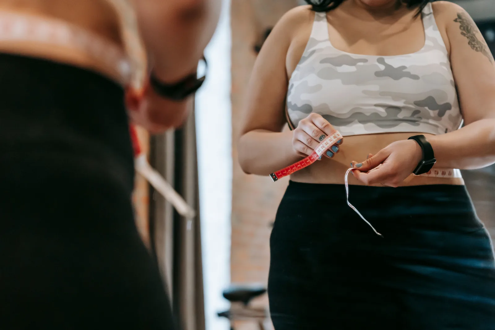Two people measuring waist circumference together