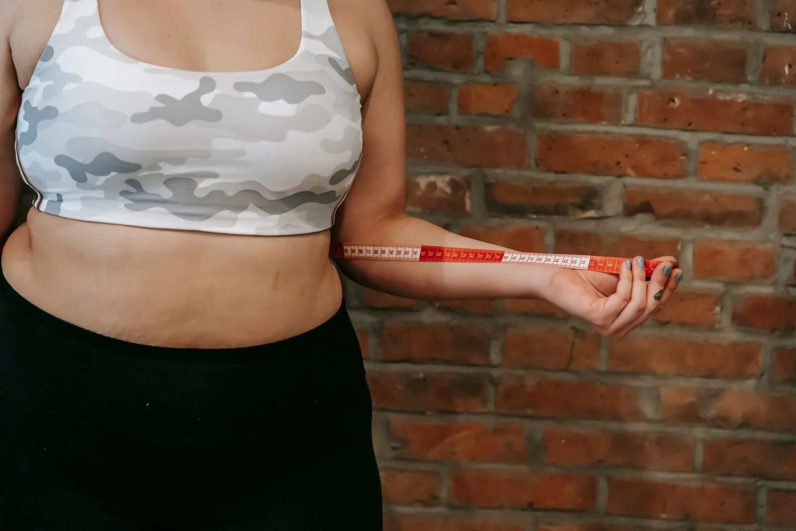 Measuring the waist against a brick wall