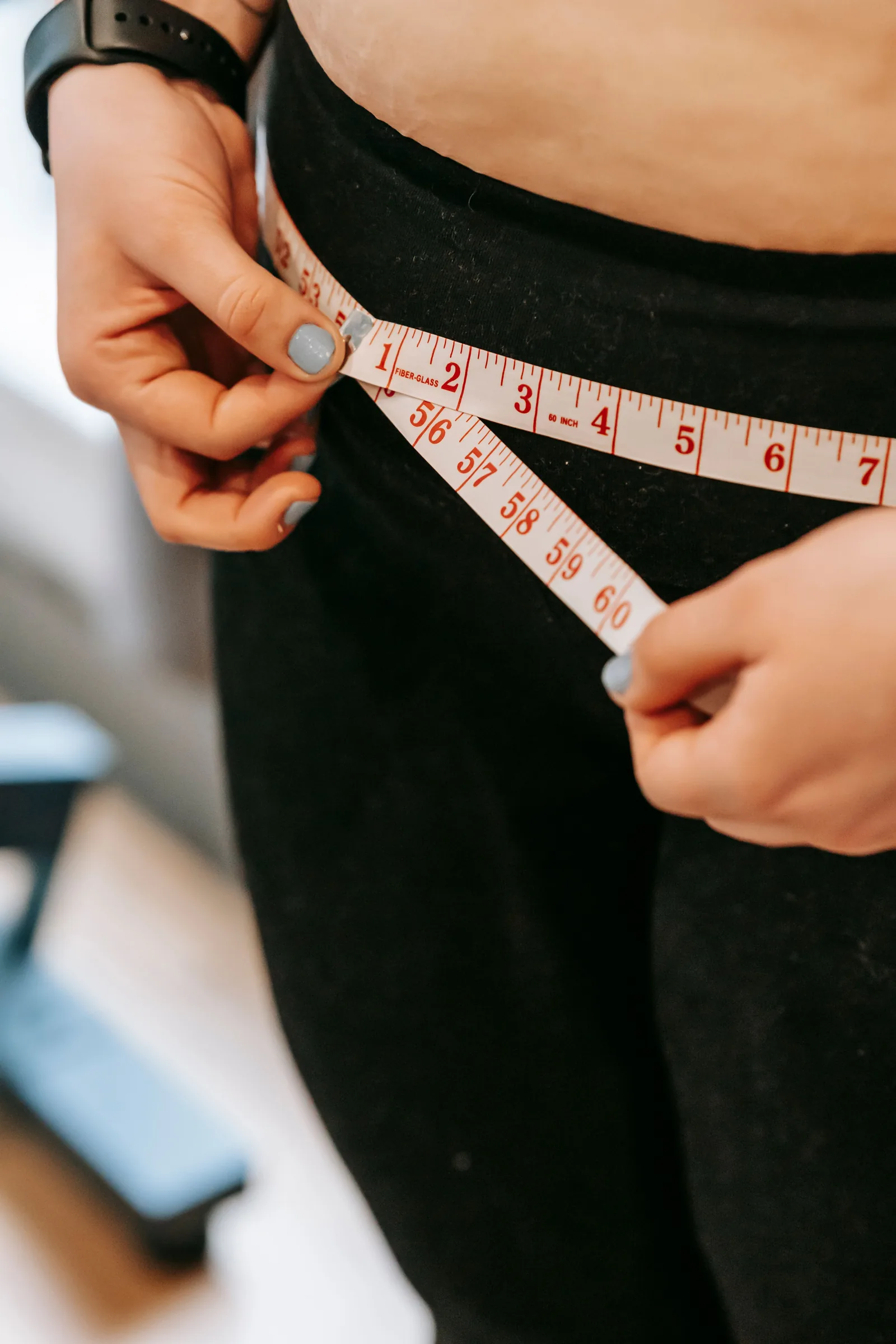 Measuring the waist in black leggings