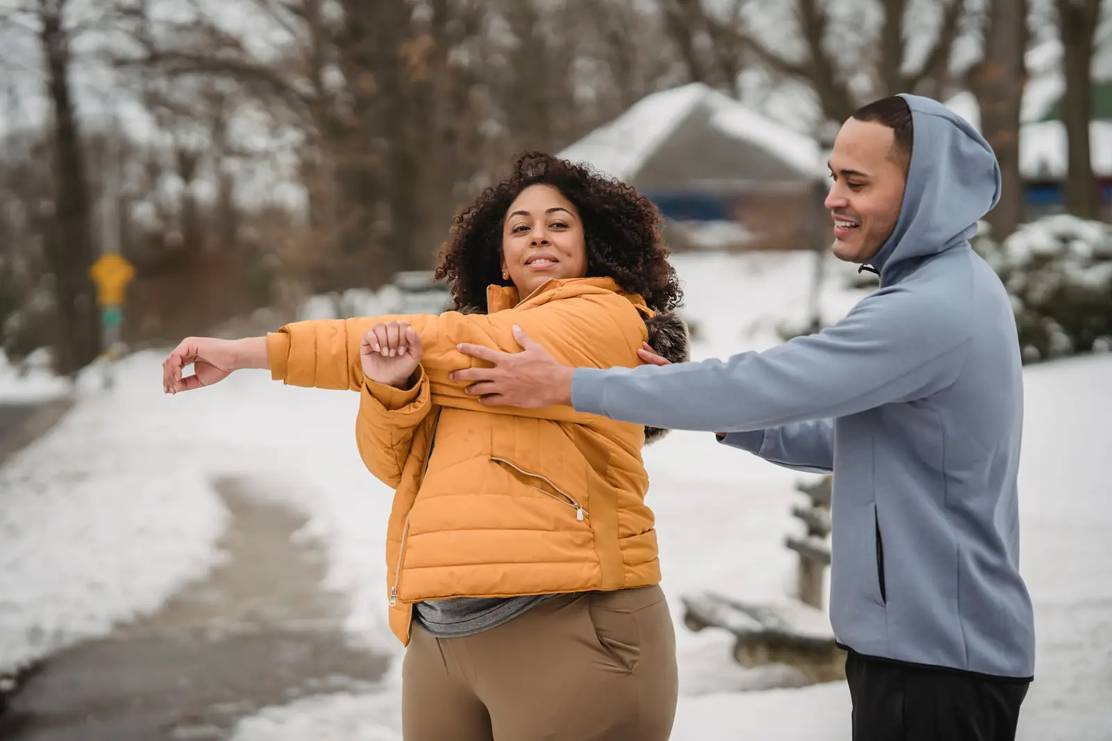 Two people stretching together outdoors in winter